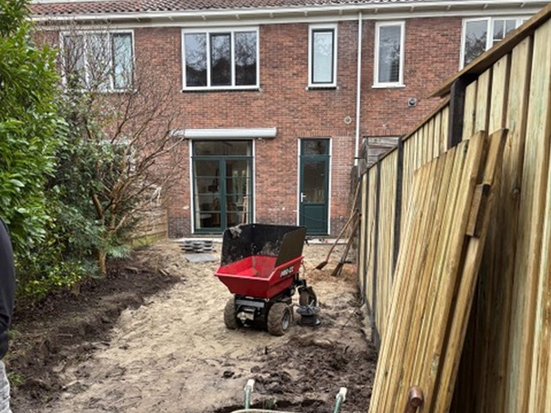 Tuin in aanleg met schuttingpanelen en een minidumper