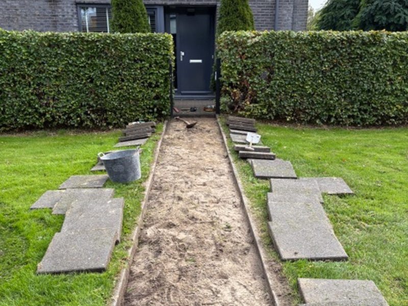 Uitgegraven tuinpad tussen twee grasvelden